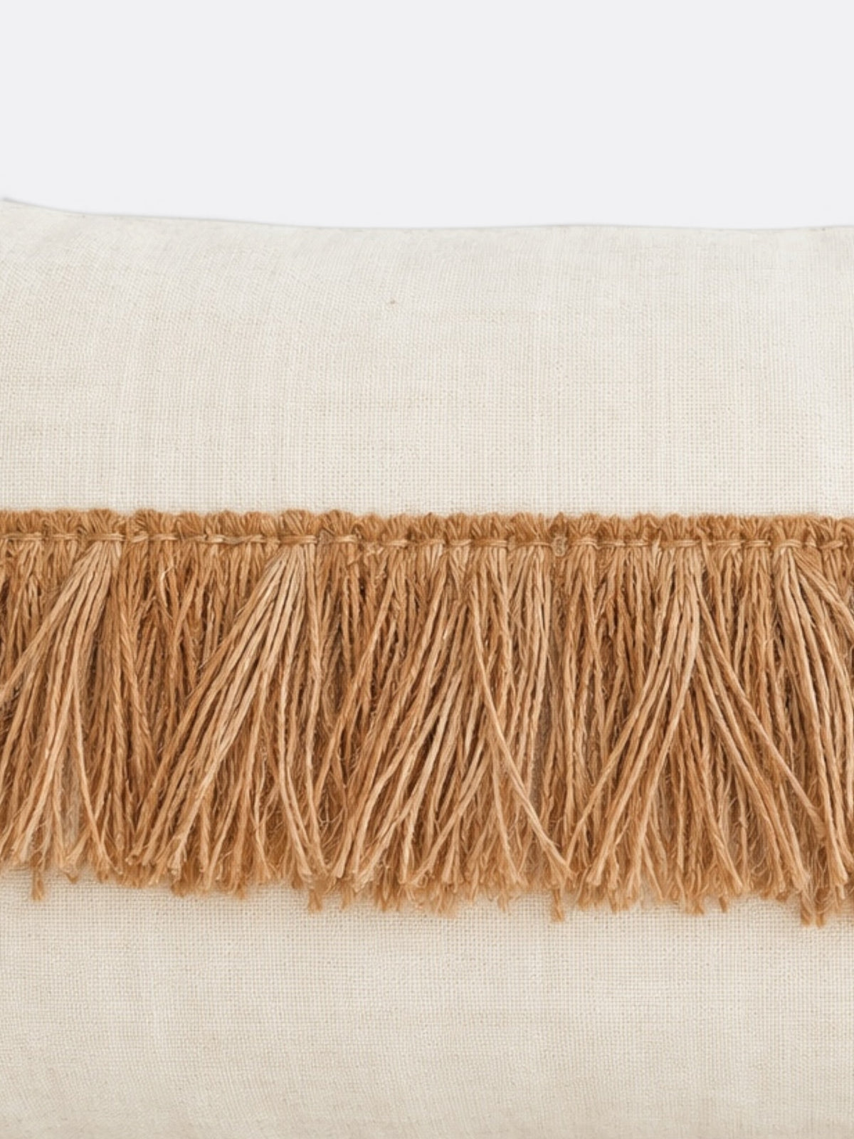 Détail des franges de coton et du tissage beige écru du coussin balinais