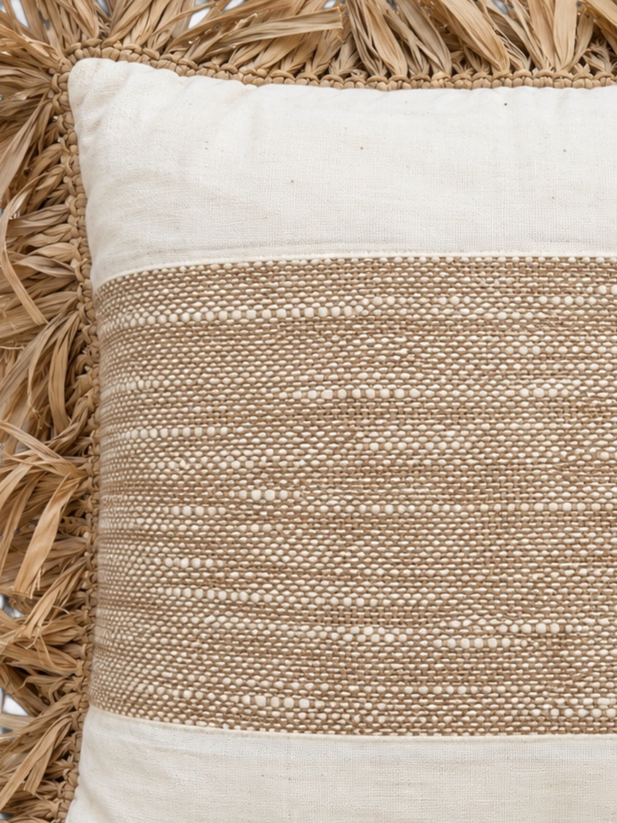 Détail du tissage écru et moutarde et d'un pompon du coussin balinais en coton