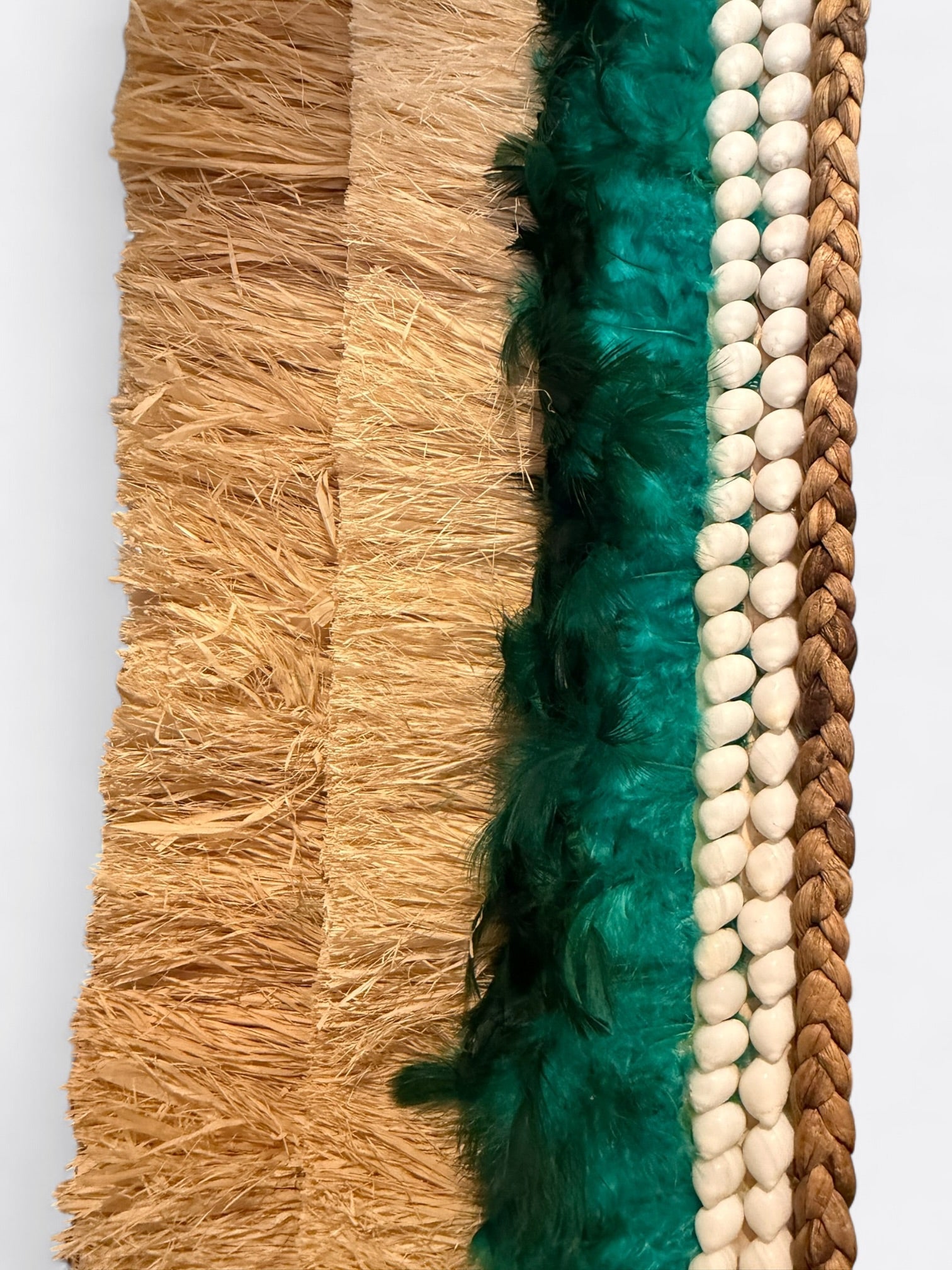 Texture organique du miroir Tahia : raphia fait main, plumes délicates et coquillages naturels