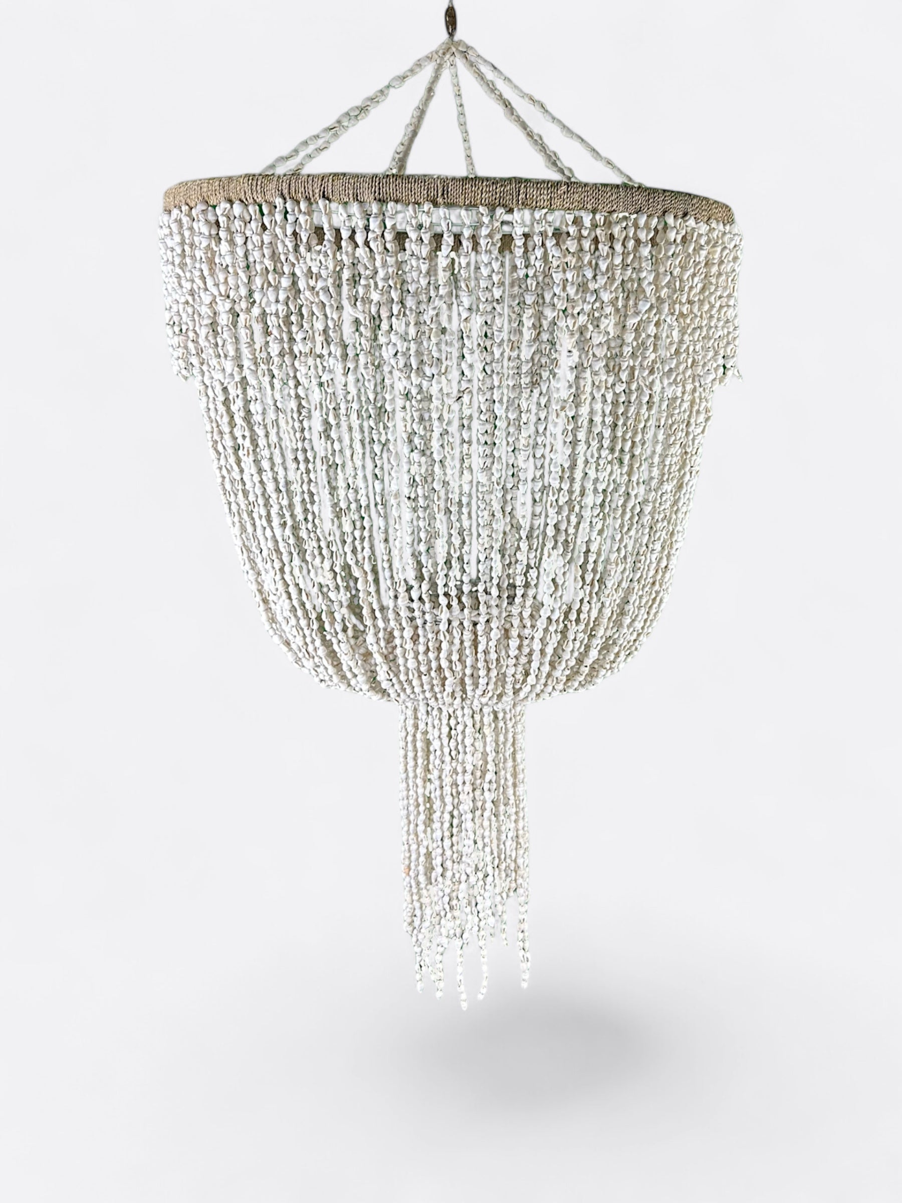 Lustre balinais en cascades de coquillages diffusant une lumière douce
