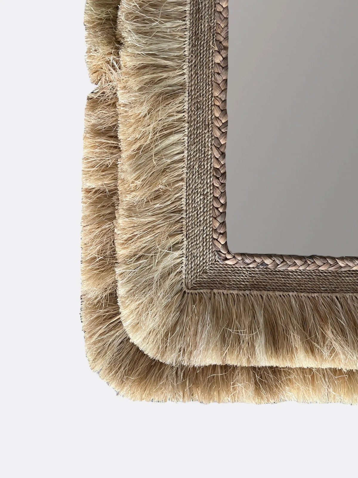 Gros plan sur le tressage en raphia et roseau beige du miroir rectangulaire Cretya