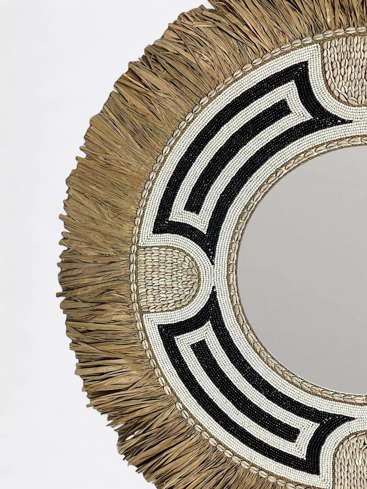 Gros plan sur les perles noires et les finitions artisanales d'un miroir de Bali
