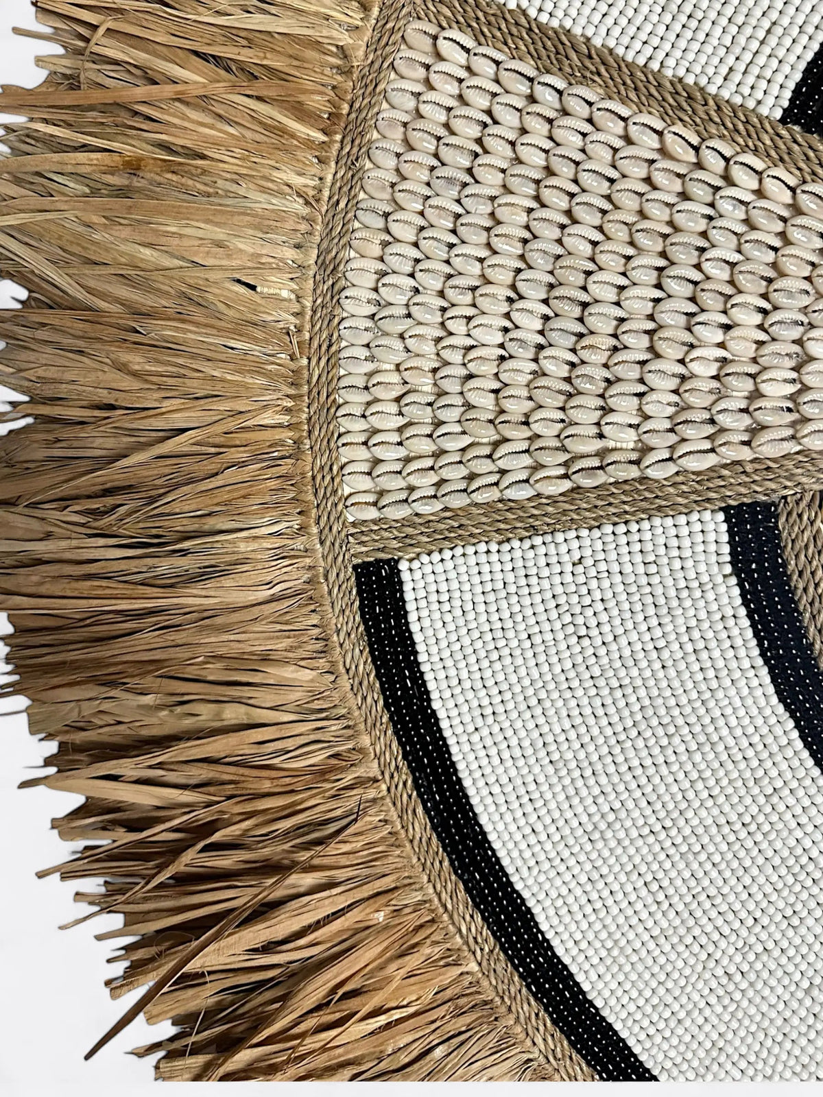 Détail de l'incrustation des perles sur le cadre blanc texturé du miroir Kaya