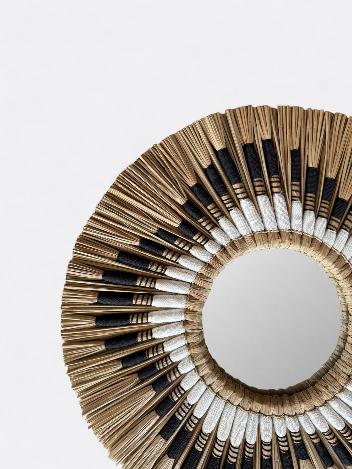 Détail de la texture organique et des fibres de roseau du cadre tressé main du miroir Lyo