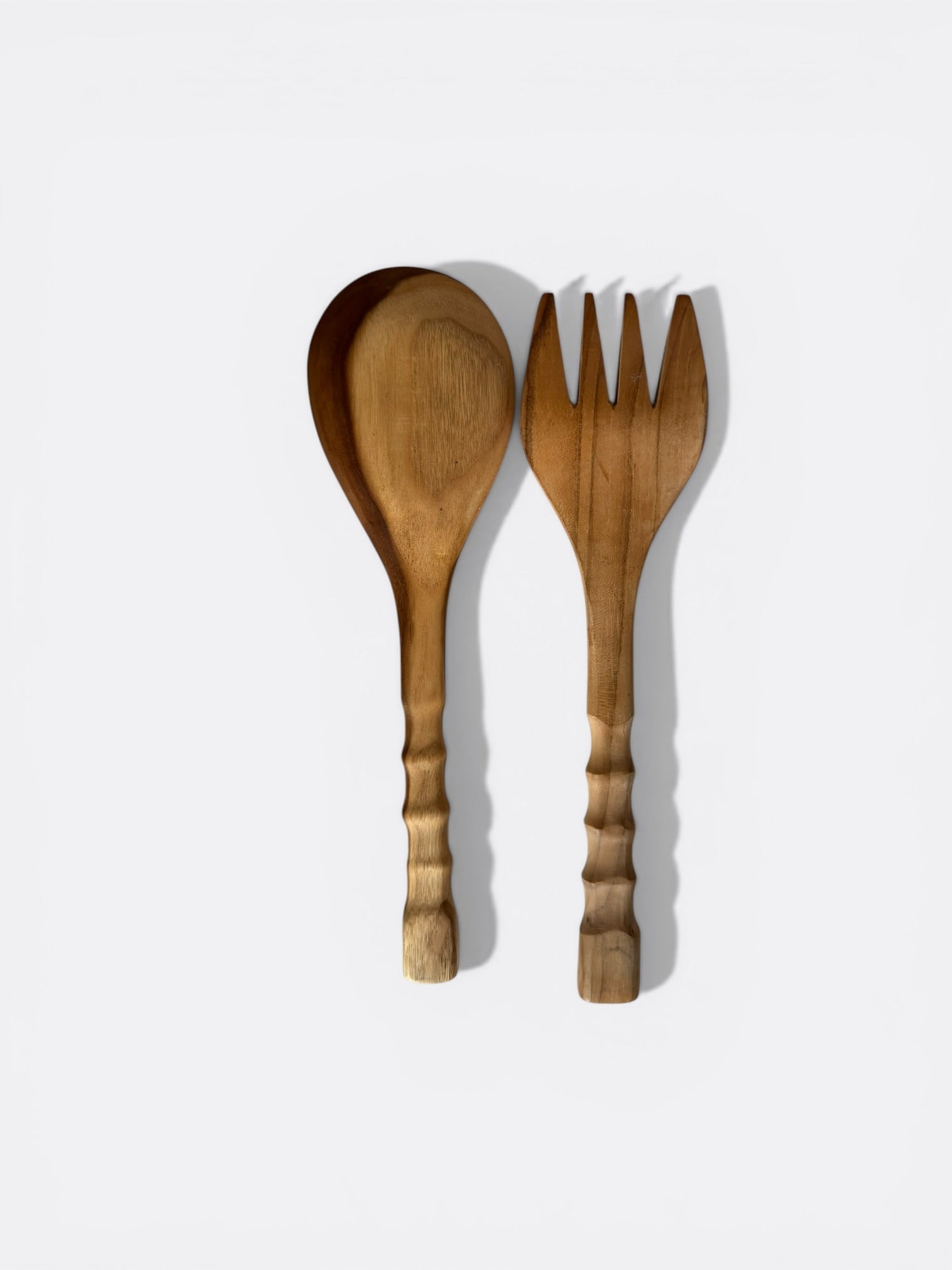 Cuillère et fourchette à salade en teck posées sur une table