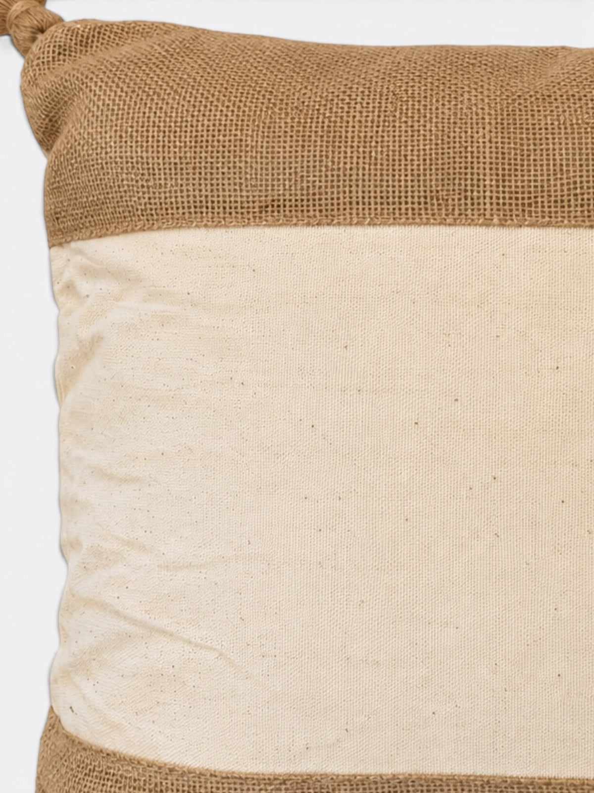 Détail du tissage beige et écru et d'un pompon du coussin balinais en coton