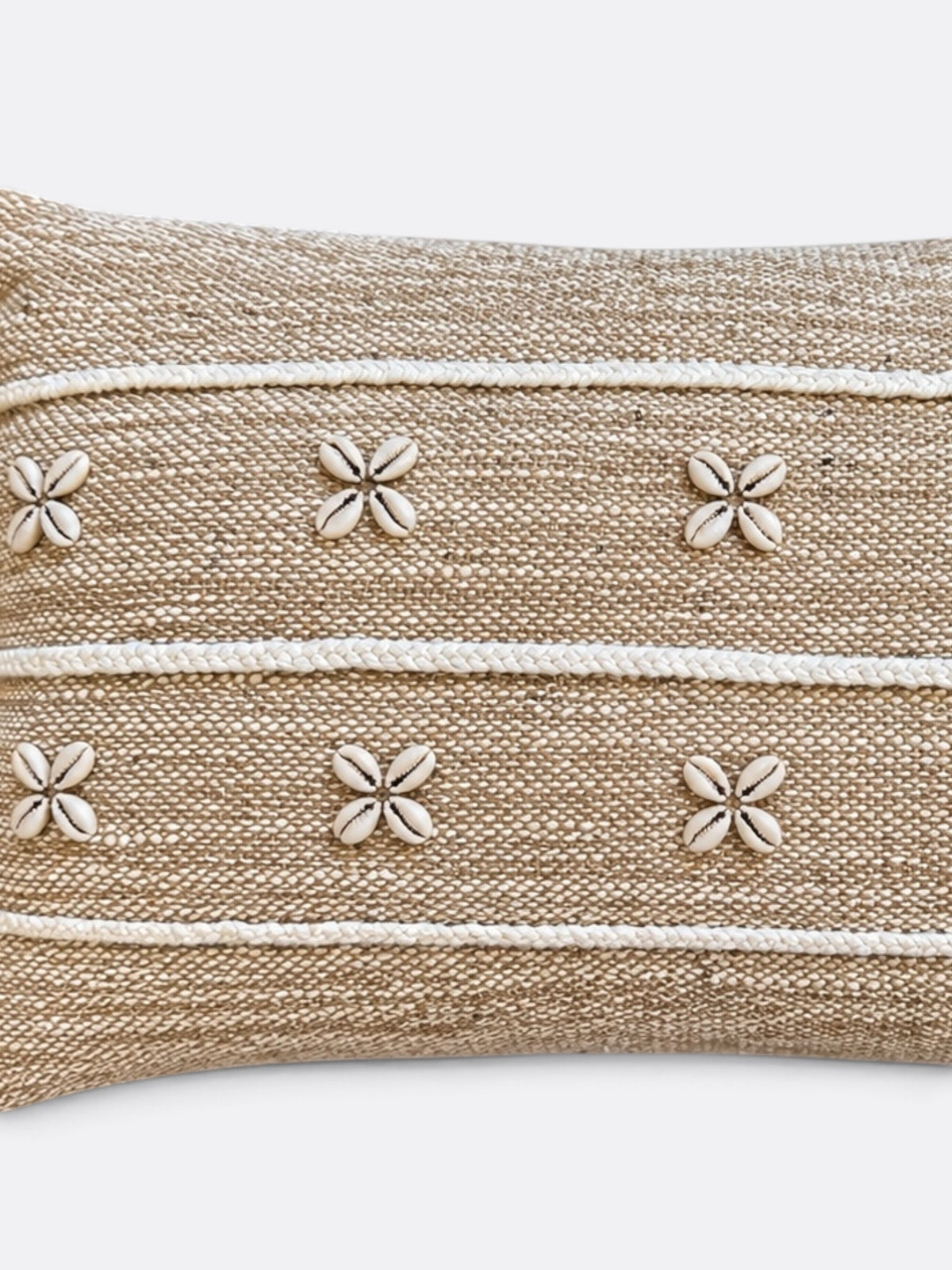 Détail des coquillages cauris et du tissage en jute beige du coussin balinais