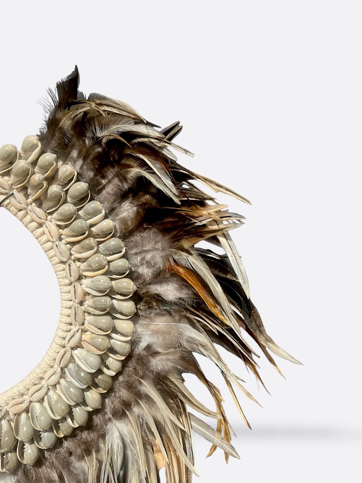 Détail des plumes et coquillages du collier Amara