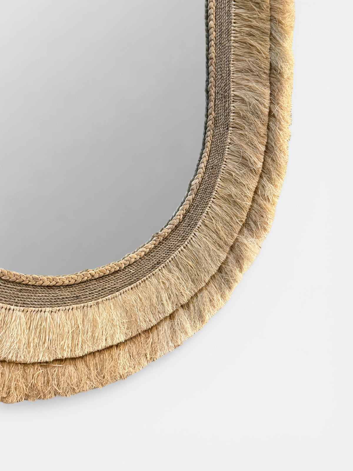 Gros plan sur la fibre de raphia tressée main du miroir Lyat - Finitions artisanales