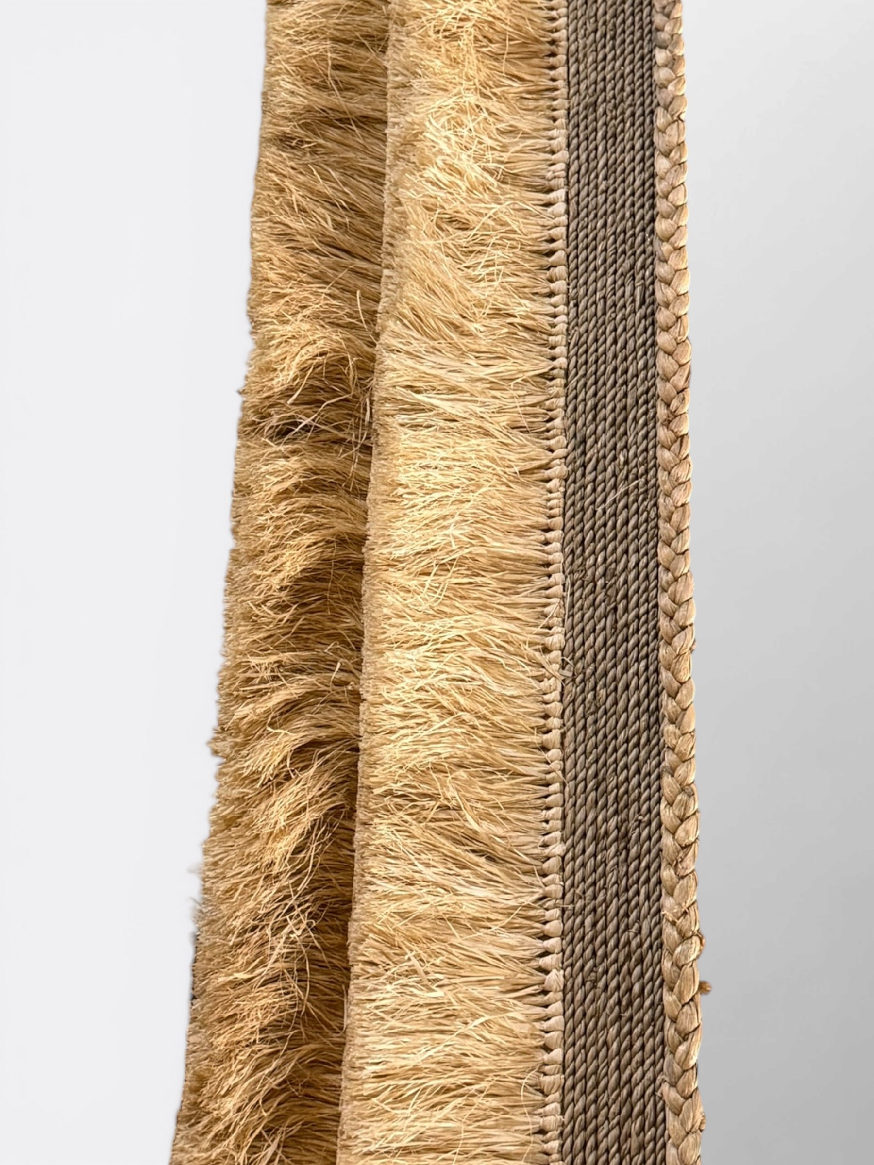 Gros plan sur la fibre de raphia tressée main du miroir Lyat - Finitions artisanales