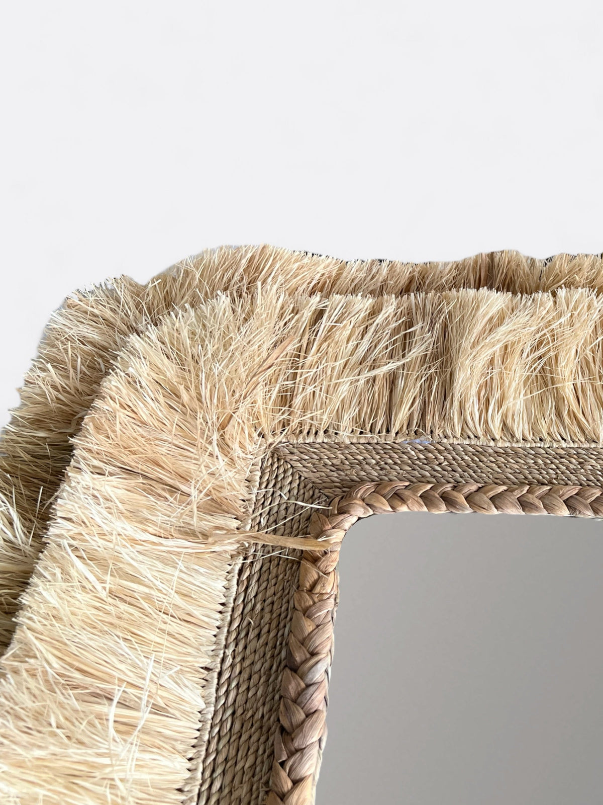 Détail de la texture organique et des fibres naturelles du cadre rectangulaire du miroir Cretya