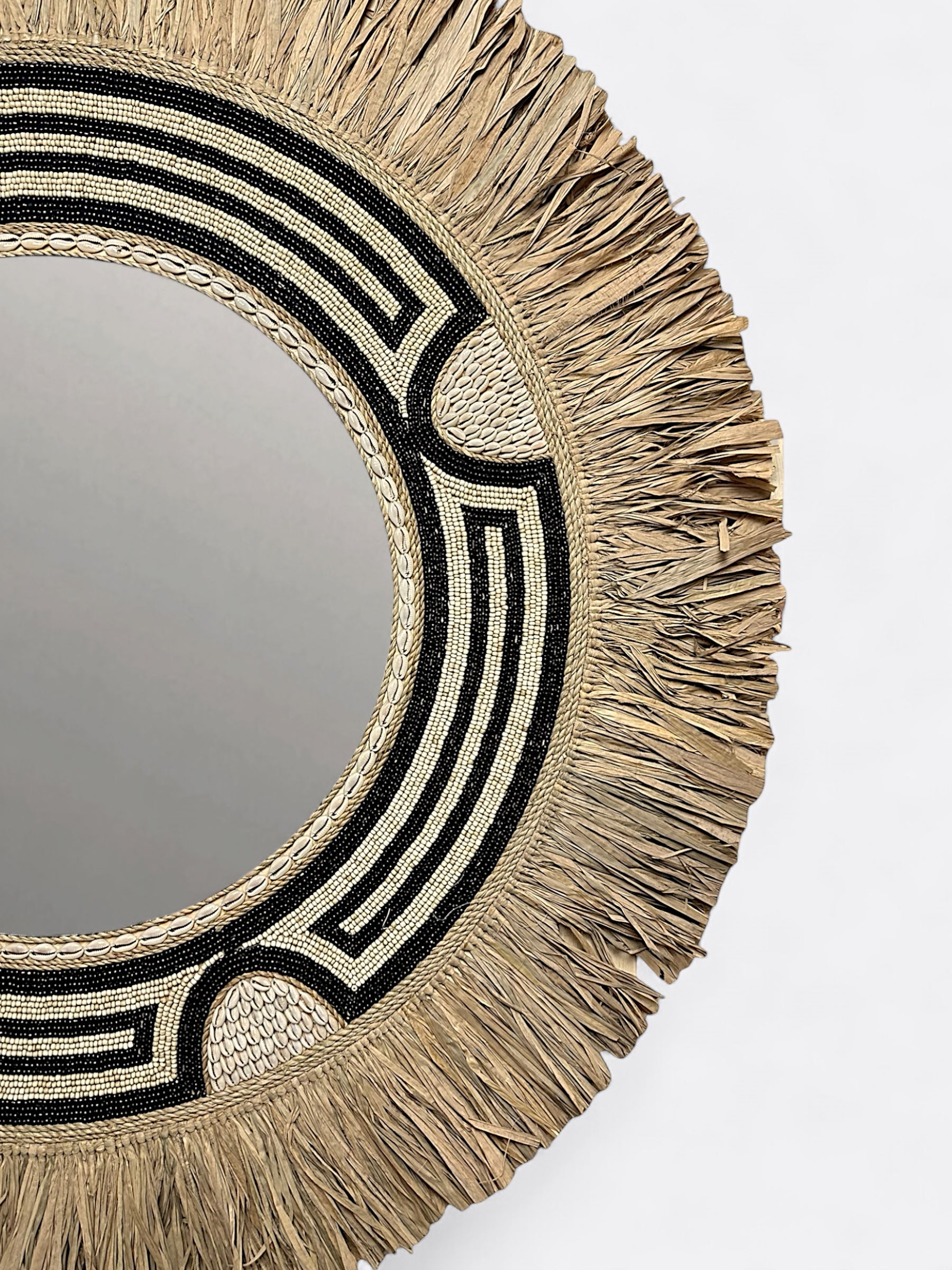 Miroir mural artisanal en raphia avec perles décoratives detail
