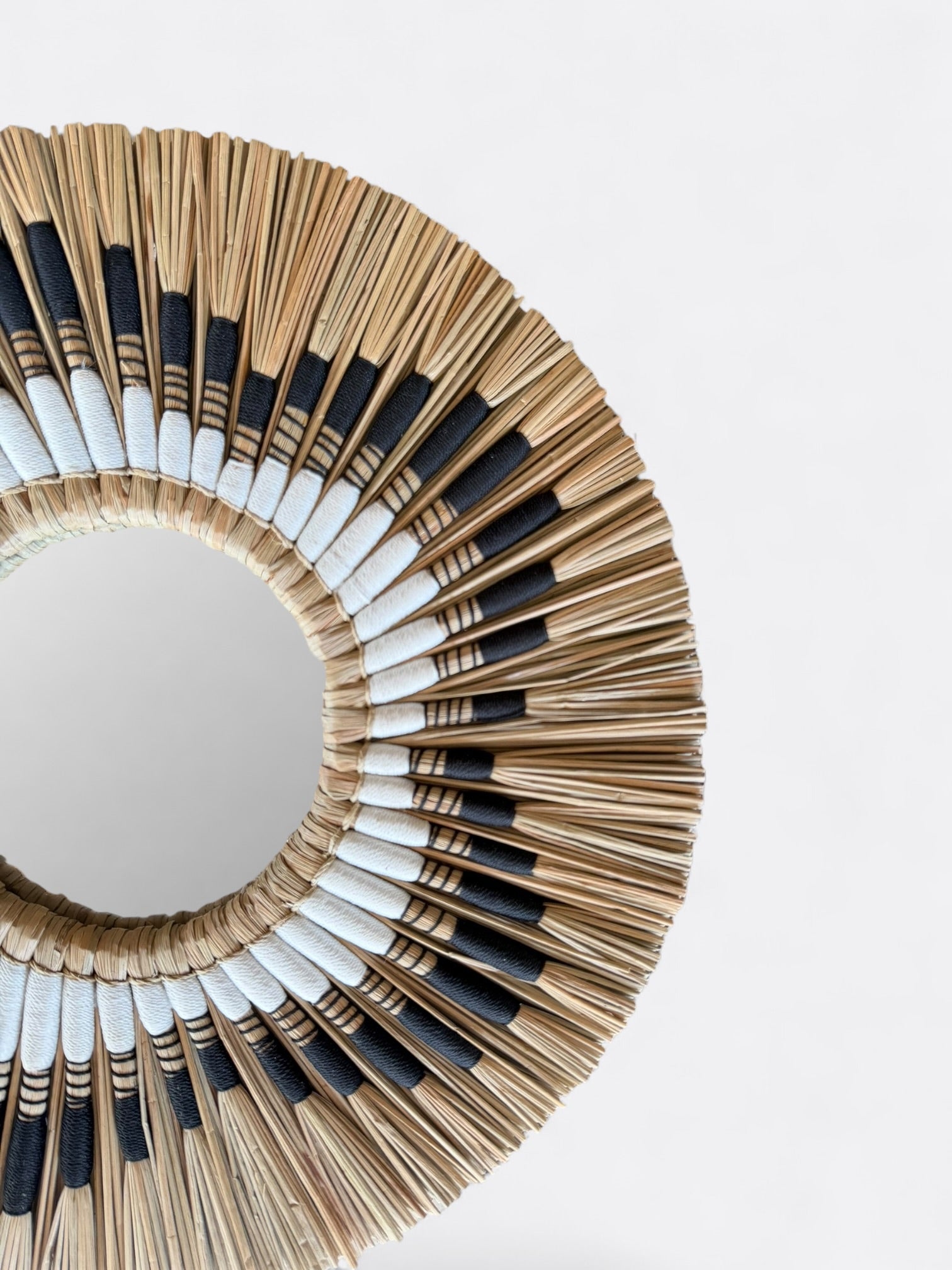 Gros plan sur le tressage en roseau naturel du petit miroir rond Lyo