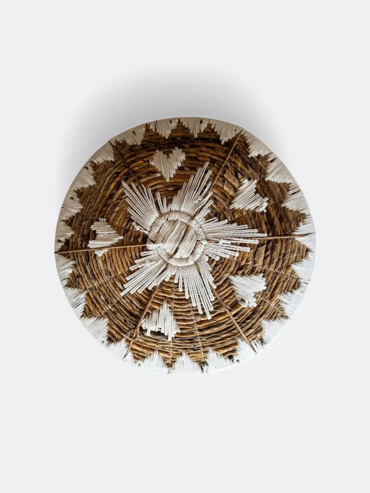 Détail des finitions artisanales et des motifs en macramé sur un set d'assiettes murales tressées